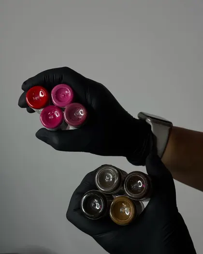 Mixed pigment cups held in a gloved hand